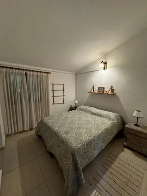 a bedroom with a bed and a light on the wall at Casita de Cuesta in Villa Icho Cruz