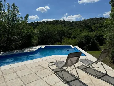 two chairs sitting in front of a swimming pool at Casita de Cuesta in Villa Icho Cruz