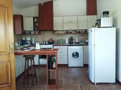 a kitchen with a refrigerator and a washer and dryer at Casa en Villa Los Aromos in La Bolsa