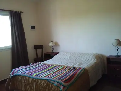 a bedroom with a bed with a striped blanket on it at Casa en Villa Los Aromos in La Bolsa