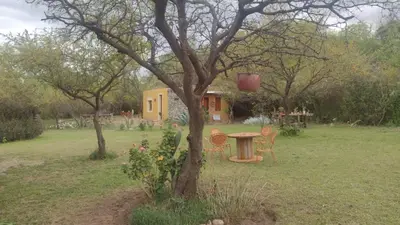 a table and chairs in a yard next to a tree at Chañares Majuk in San Javier
