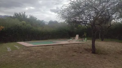 a swimming pool with a bench next to a tree at Chañares Majuk in San Javier