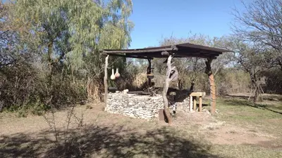 a stone shelter in a field with a tree at Chañares Majuk in San Javier