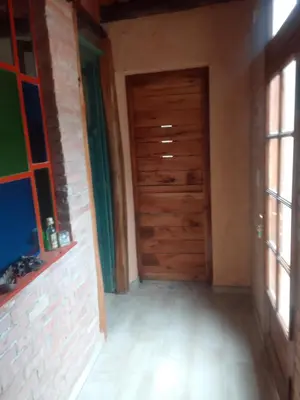 an empty room with a wooden door and windows at Chañares Majuk in San Javier