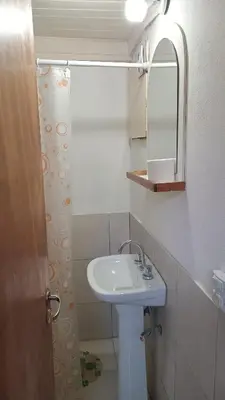 a white bathroom with a sink and a mirror at CABAÑAS BALCON DE PEHUMAYEN in Villa Carlos Paz