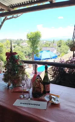a table with two wine bottles and a christmas tree at CABAÑAS BALCON DE PEHUMAYEN in Villa Carlos Paz