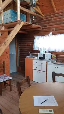 a kitchen and dining room with a table in a cabin at CABAÑAS BALCON DE PEHUMAYEN in Villa Carlos Paz
