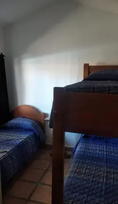 two beds in a room with two bedsskirts at Cabaña Paulina in Santa Rosa de Calamuchita