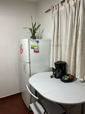 a white table and a white refrigerator in a room at Apartamento El Colibri in Cordoba