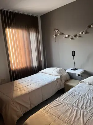a bedroom with two beds next to a window at Apartamento El Colibri in Cordoba