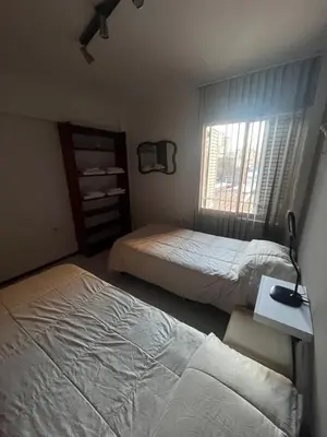 a bedroom with two beds and a desk and a window at Apartamento El Colibri in Cordoba