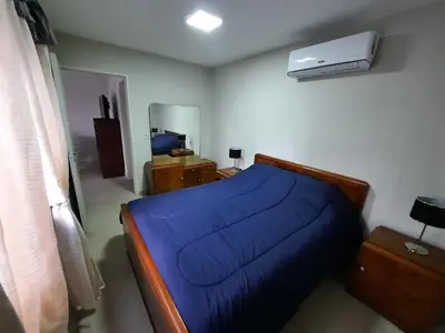 a bedroom with a blue bed and a air conditioner at COMPLEJO CRUZ in Alta Gracia