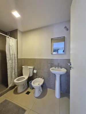 a bathroom with two toilets and a sink at COMPLEJO CRUZ in Alta Gracia
