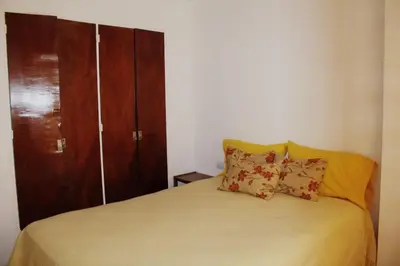 a bedroom with a bed with a wooden cabinet at Mi depto en Córdoba II . in Cordoba