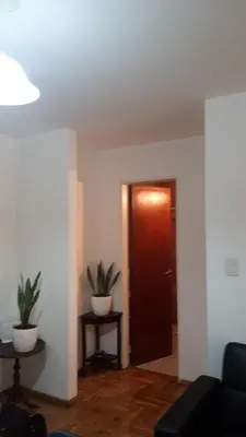 a living room with a door and two potted plants at Mi depto en Córdoba II . in Cordoba