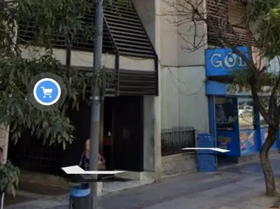 a woman sitting outside of a building with a sign at Mi depto en Córdoba II . in Cordoba