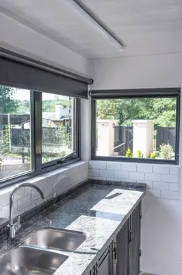 a kitchen with a sink and two windows at Laurentino Loft & Home in Villa General Belgrano
