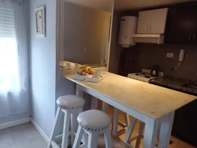 a kitchen with a counter and stools in a room at MM Apart in Río Cuarto
