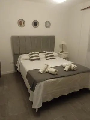 a bedroom with a large bed with three pillows at MM Apart in Río Cuarto