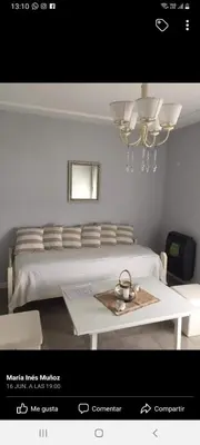 a bedroom with a bed with a table and a chandelier at MM Apart in Río Cuarto