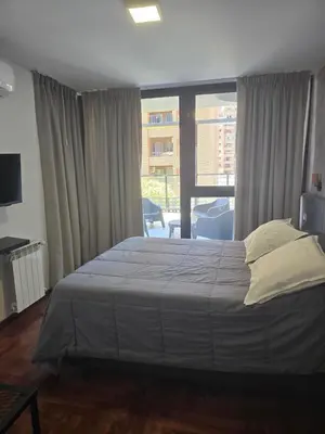 a bedroom with a large bed and a large window at LOCADOR Nueva Cordoba 3C in Cordoba