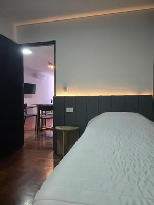 a bedroom with a bed and a living room with a table at LOCADOR Nueva Cordoba 3C in Cordoba