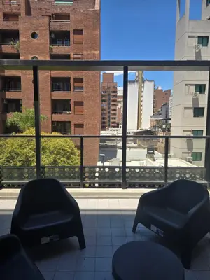 a balcony with two chairs and a view of a city at LOCADOR Nueva Cordoba 3C in Cordoba