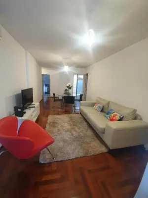 a living room with a couch and a red chair at Nueva Cordoba 3D in Cordoba