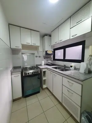a kitchen with white cabinets and a stove top oven at Nueva Cordoba 3D in Cordoba