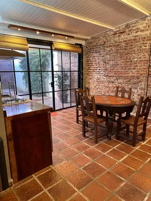 a dining room with a table and chairs and a brick wall at LO DE CAPRETTA in Almafuerte