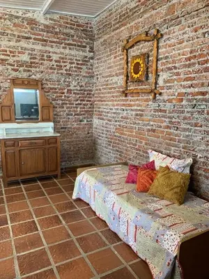 a room with a bed and a brick wall at LO DE CAPRETTA in Almafuerte