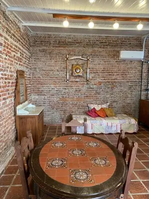 a room with a table and a brick wall at LO DE CAPRETTA in Almafuerte