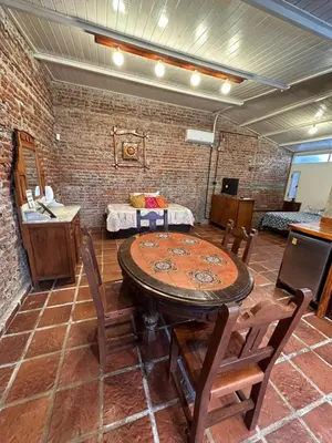 a room with a table and chairs and a brick wall at LO DE CAPRETTA in Almafuerte