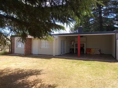 a small white house with a red pole at Cabaña Los Pajaritos in Villa Rumipal