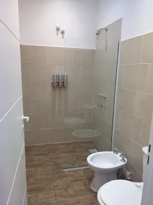 a bathroom with a shower and a toilet and a sink at Cabaña Los Pajaritos in Villa Rumipal