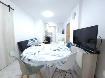 a living room with a table with chairs and a tv at Milca Celeste Nueva Córdoba in Cordoba