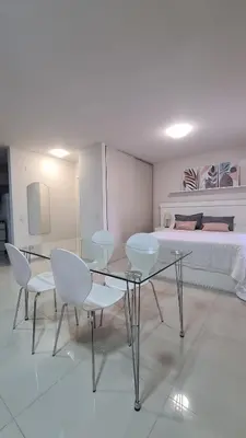 a room with a table and chairs and a bed at II Opera Towers Villa Carlos Paz in Villa Carlos Paz