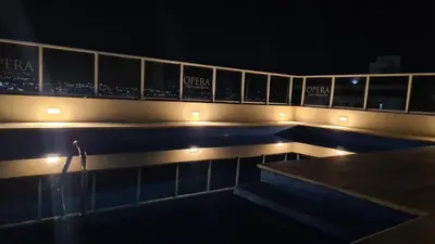 a swimming pool with lights on the side of a building at II Opera Towers Villa Carlos Paz in Villa Carlos Paz