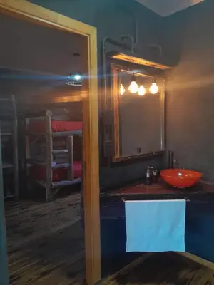 a bathroom with a red sink and a mirror at Cabañas LA IRMA in Villa Ciudad Parque