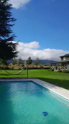 a swimming pool in front of a house at Cabañas LA IRMA in Villa Ciudad Parque