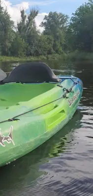 a green boat sitting on a body of water at Cabañas Sol Marina in Villa Parque Siquiman
