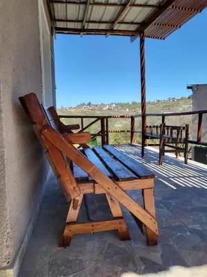 a wooden bench sitting on the porch of a house at Cabañas Sol Marina in Villa Parque Siquiman