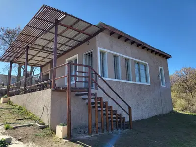 a house with a staircase in front of it at Cabañas Sol Marina in Villa Parque Siquiman