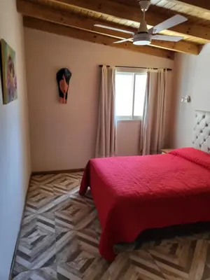 a bedroom with a red bed and a window at Cabañas Sol Marina in Villa Parque Siquiman