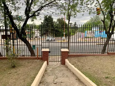 a black iron fence with a gate in a park at casa de marta a 50 mts del centro in Villa Carlos Paz