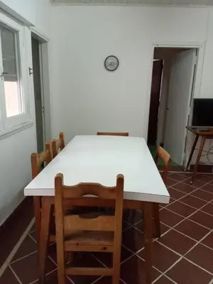 a dining room with a white table and chairs at casa de marta a 50 mts del centro in Villa Carlos Paz