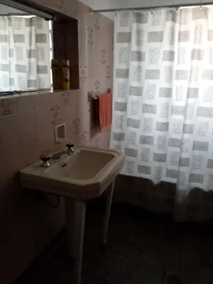 a bathroom with a sink and a shower curtain at casa de marta a 50 mts del centro in Villa Carlos Paz