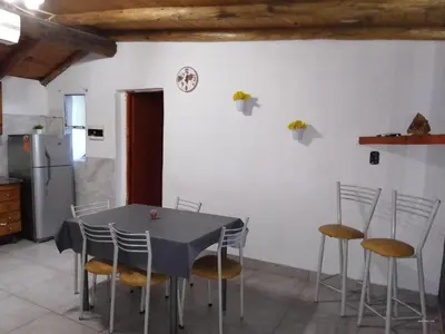 a kitchen with a table with chairs and a refrigerator at Ohana in Cordoba