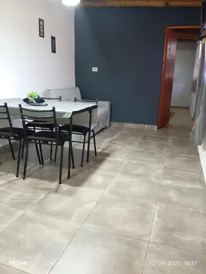 a dining room with a table and chairs and a couch at Ohana in Cordoba
