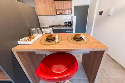 a kitchen with a wooden table with a red chair at Viaggiato Duarte Quirós in Cordoba